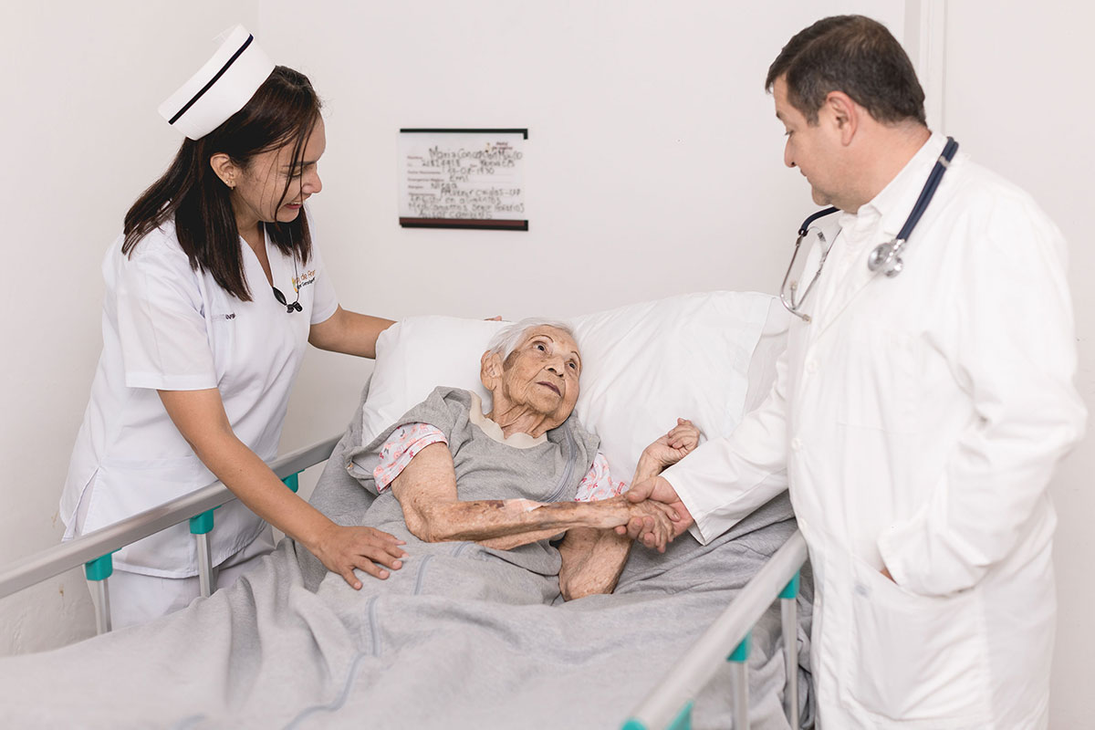 Enfermera y médico atienden a una paciente en cama