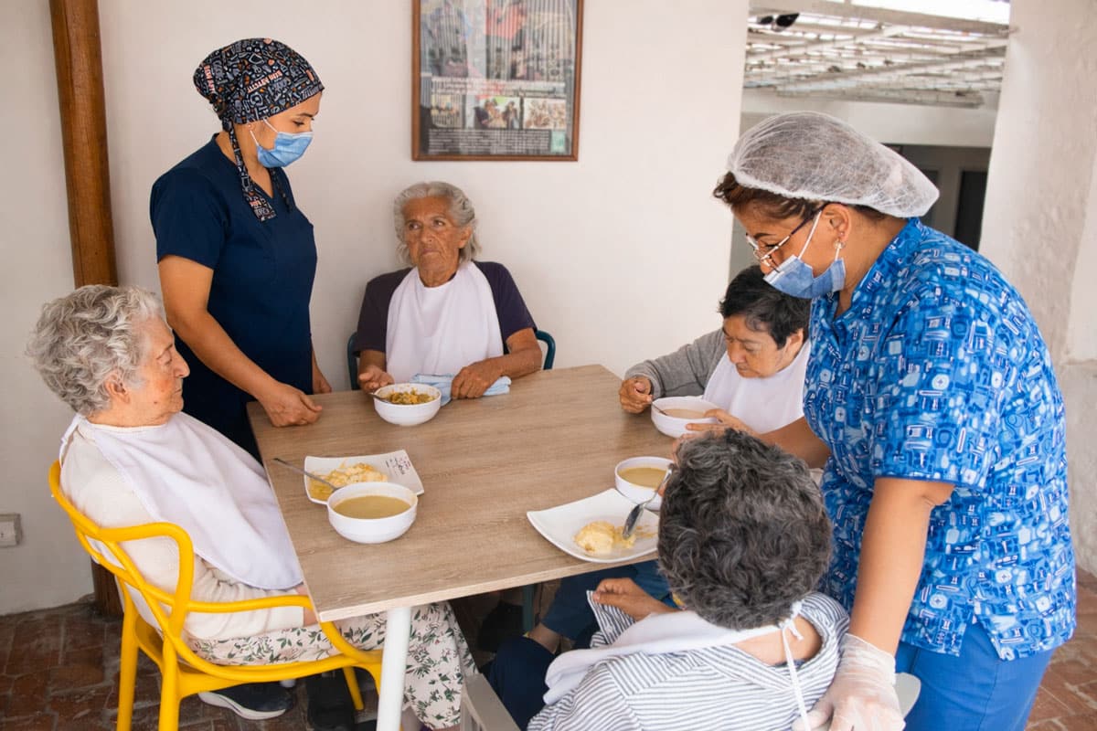 Personal de cocina sirve el almuerzo a los residentes