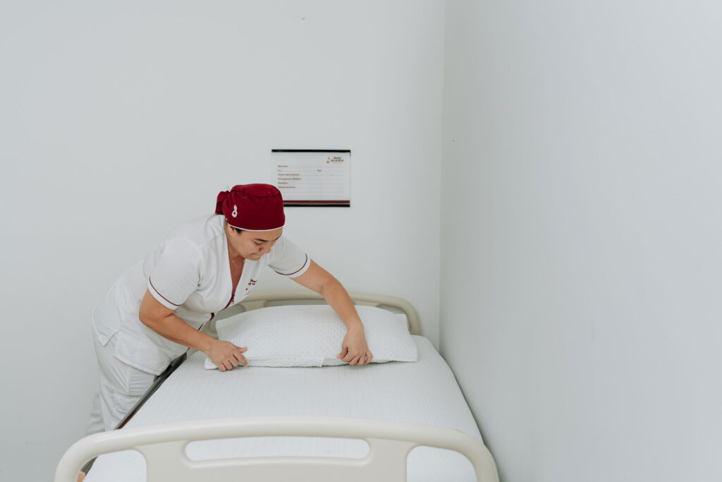 Auxiliar tiende la cama en una habitación del centro