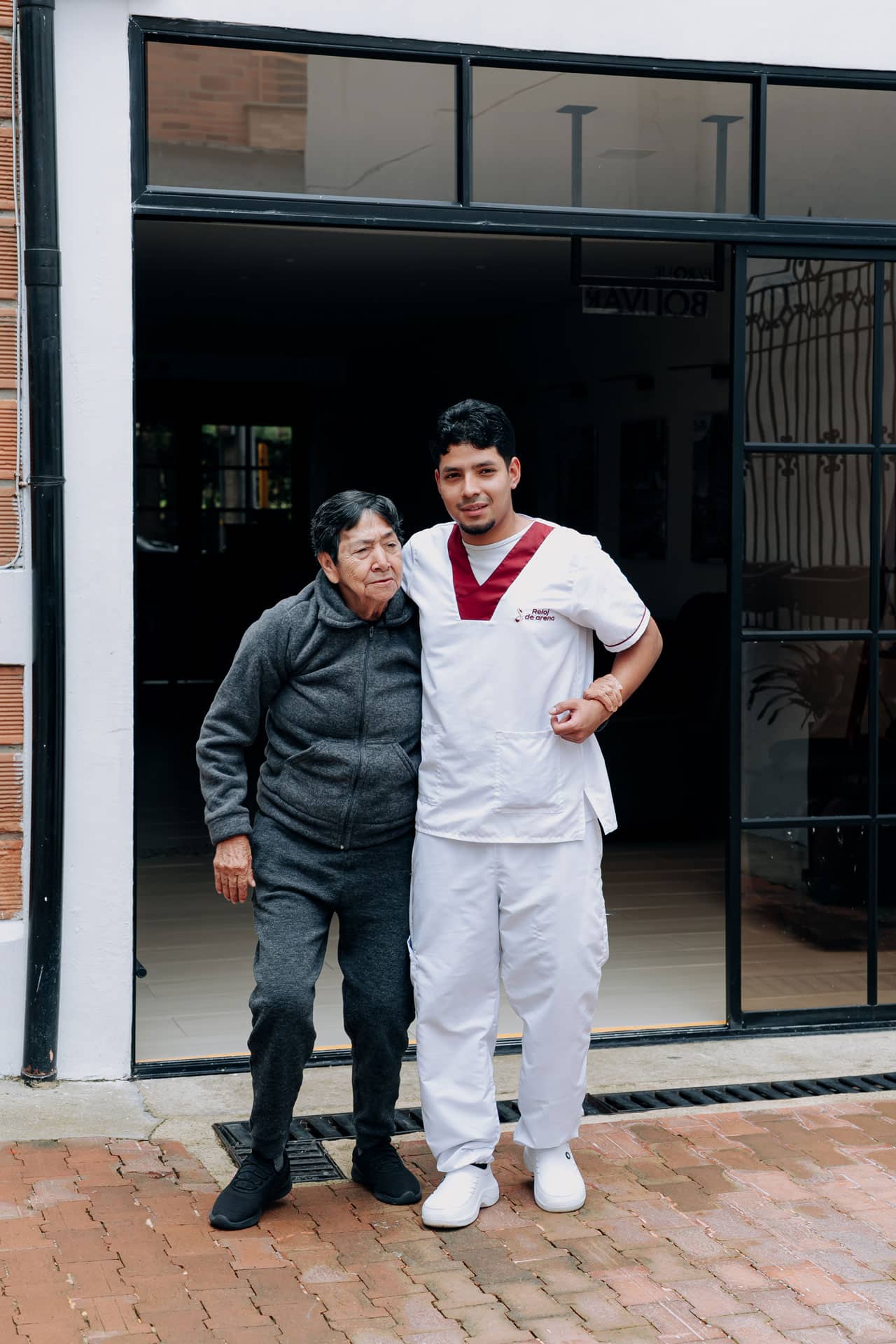 Cuidador acompaña a una adulta mayor en el centro de día